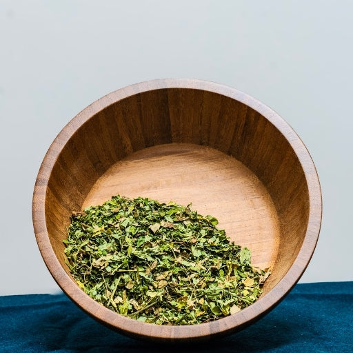 Moringa Leaf (Moringa Oleifera) dried herb in wooden bowl